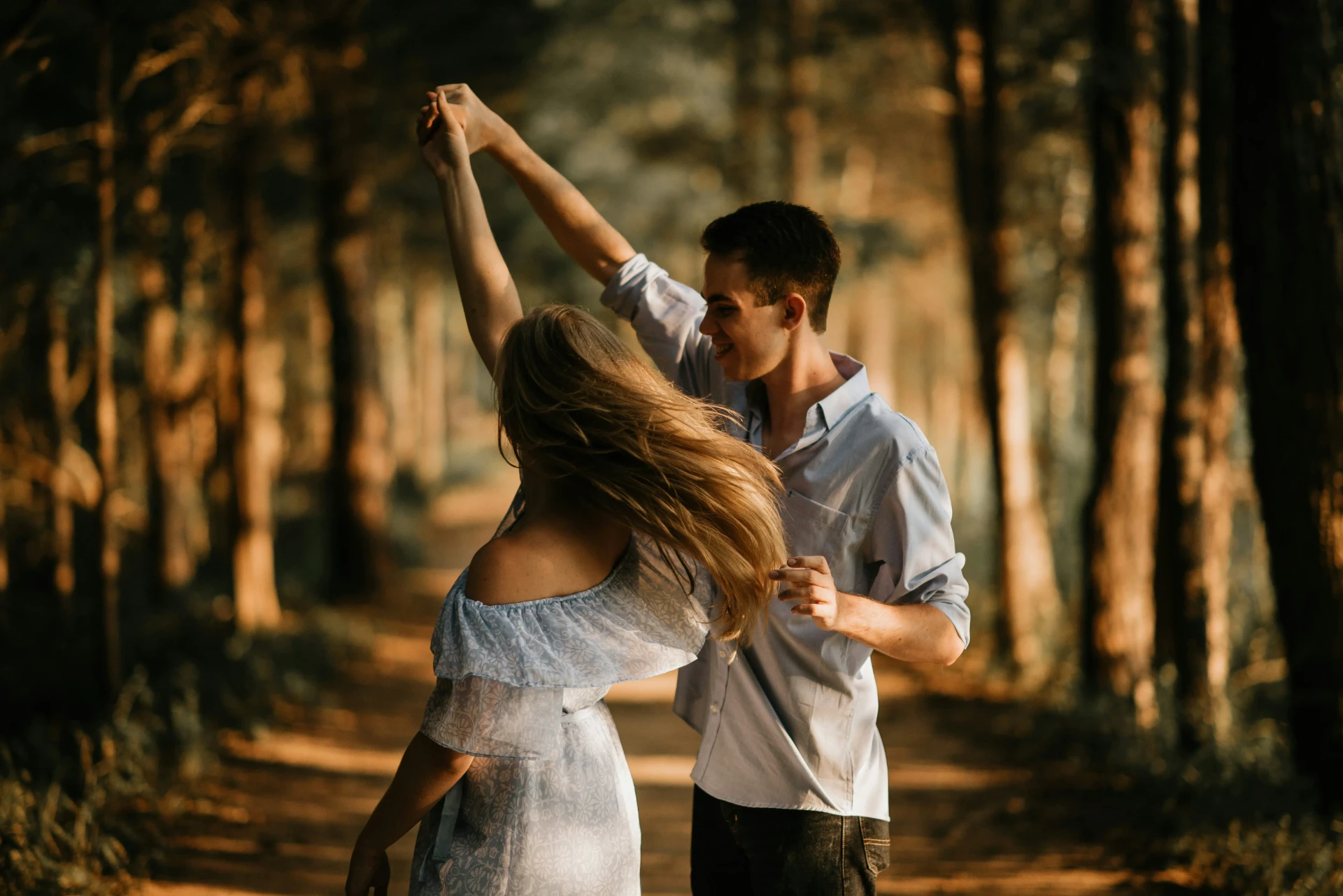 Tanzendes Paar im Abendlicht auf einem Waldweg – Salsa- und Tanzreisen